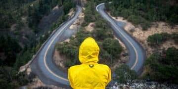 person in yellow coat standing on top of hill