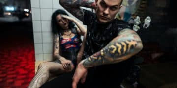 man sitting next to woman leaning on wall