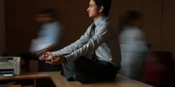 man in white and blue pinstripe dress shirt sitting on brown wooden table