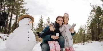 2 girls sitting on white snowman